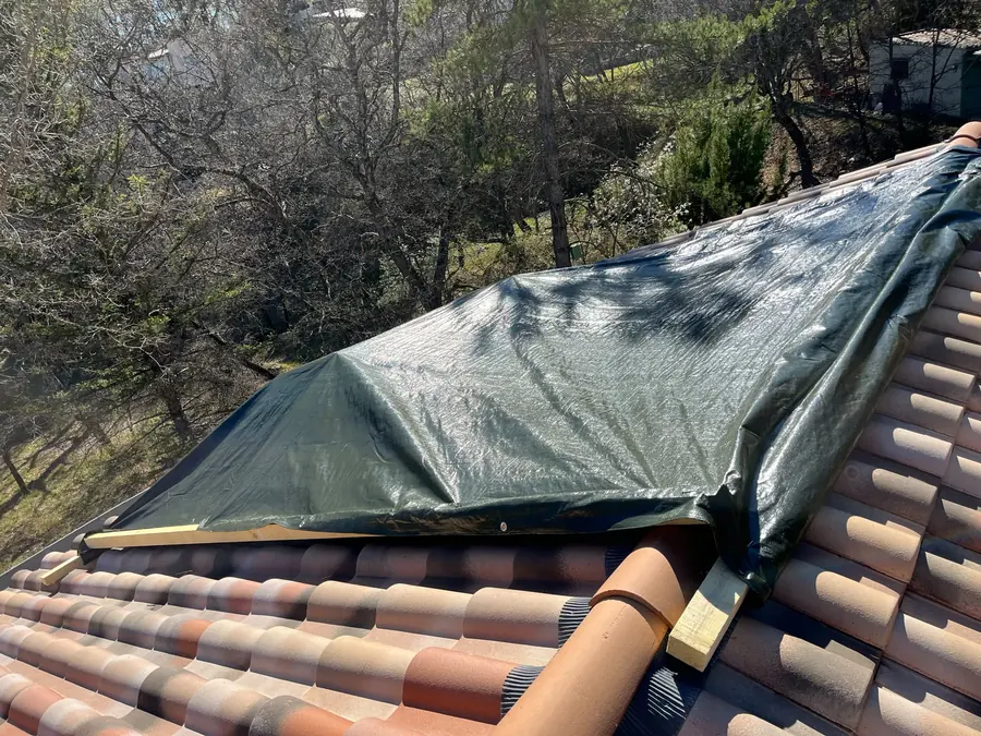 Pose de tuiles neuves et bâchage de protection sur un chantier de couverture en PACA